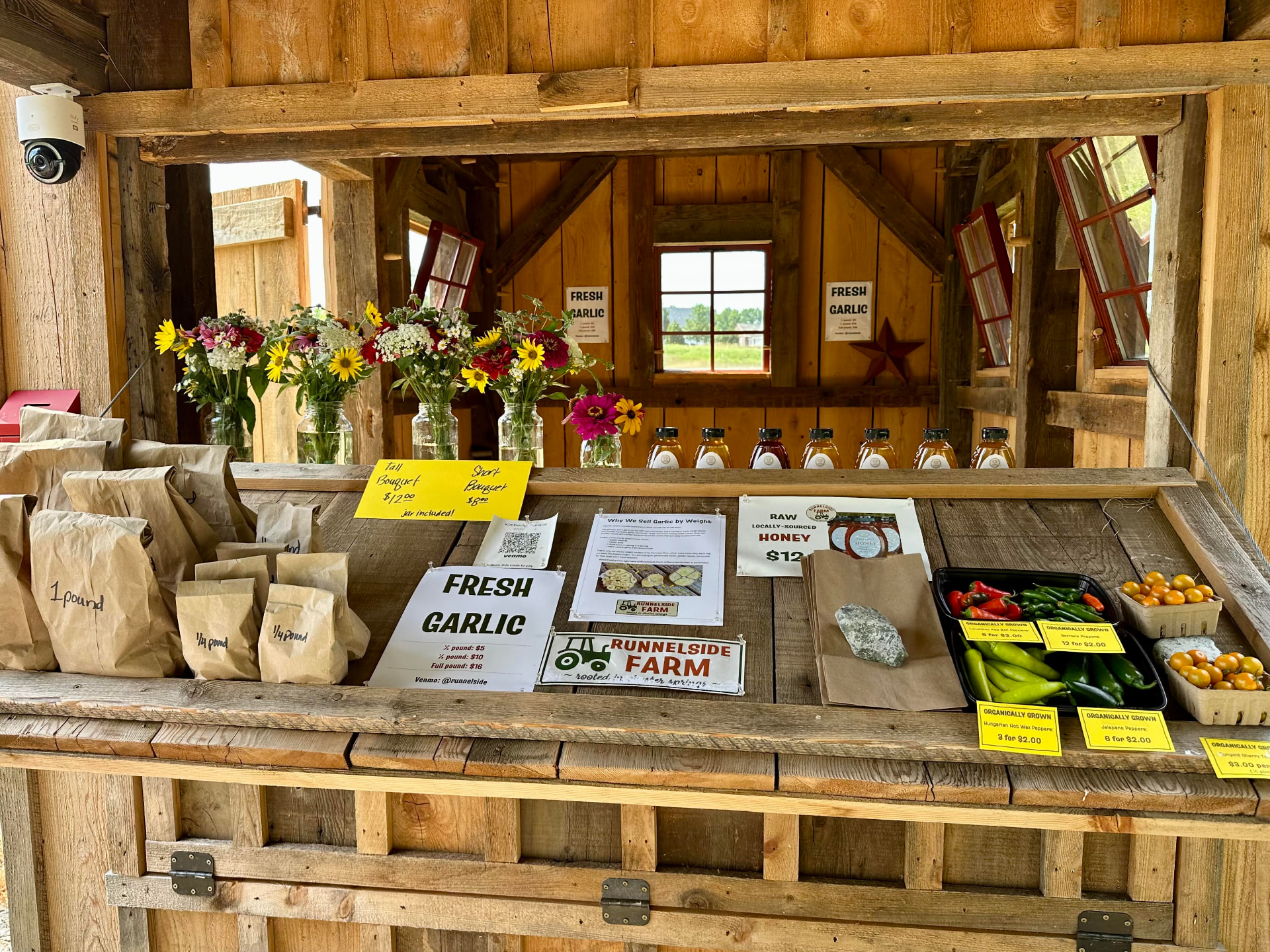 The Runnelside farm stand counter stocked with fresh garlic, honey, flowers, and peppers